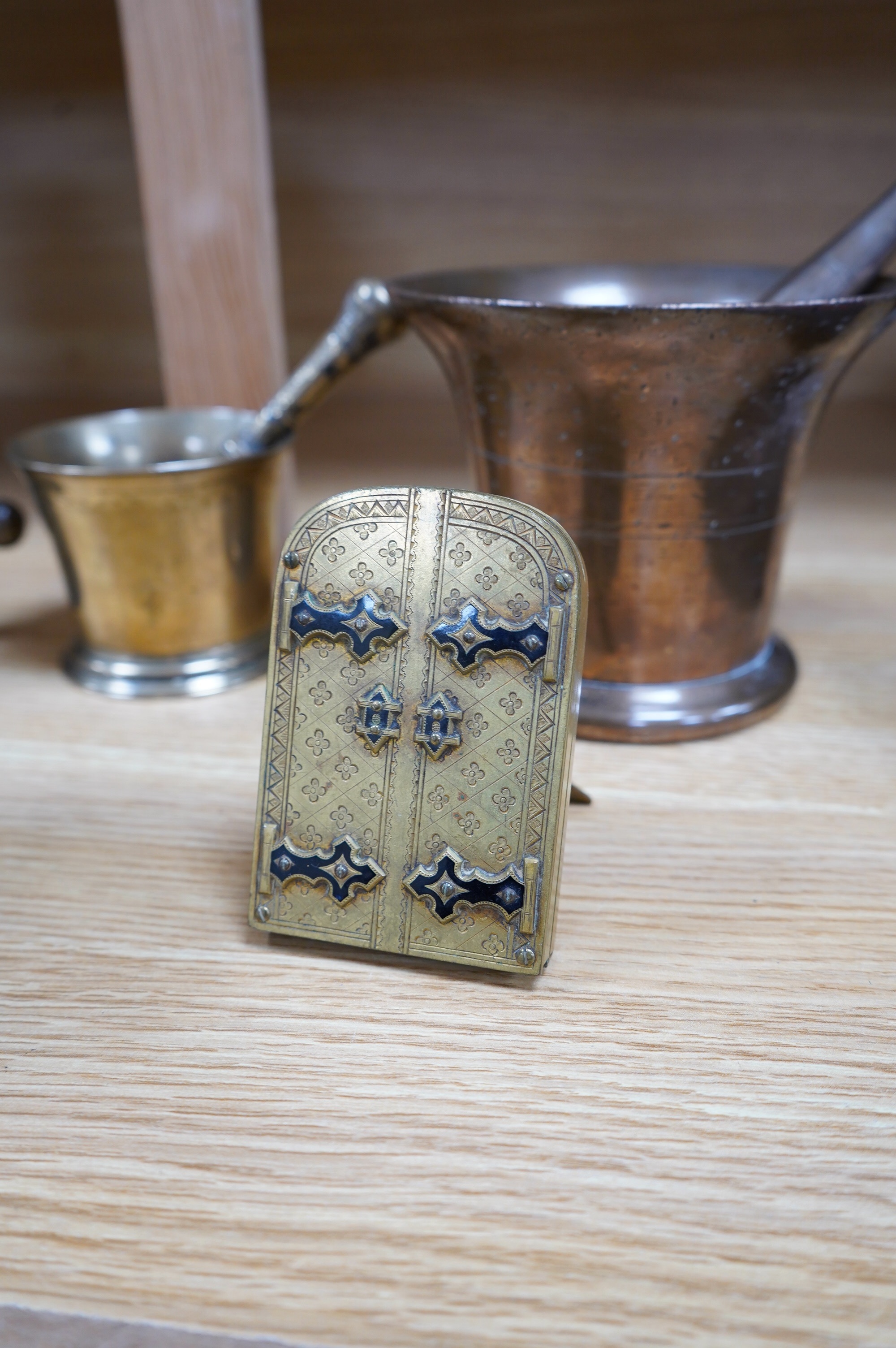 Four various bronze pestles and mortars and a small enamelled brass photograph frame, largest mortar 13cm high. Condition - fair